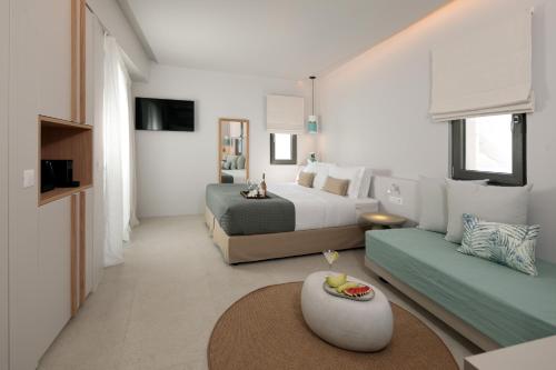 een hotelkamer met een bed en een bank bij Anapollo Boutique Hotel Adults Only in Naxos Chora