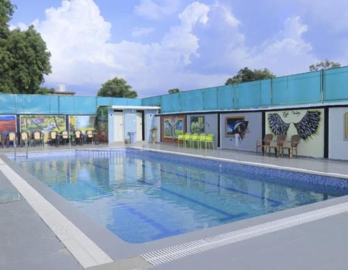 a large swimming pool in front of a building at Tiger Heaven Resort in Bandhogarh Fort