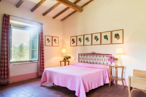 a bedroom with a pink bed and a window at Petrolo in Bucine