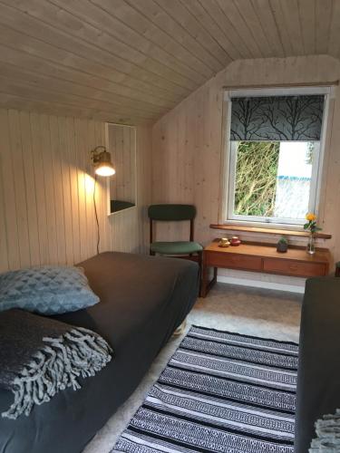 a bedroom with a bed and a desk and a window at Stunning Romantic Cabin close to Baltic see in Idestrup