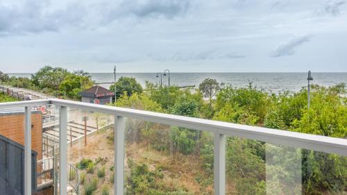 a view of the ocean from the balcony of a house at Jantaris, Sun & Snow in Mielno