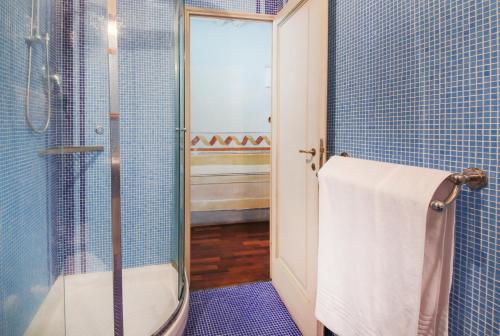 ein blau gefliestes Bad mit einer Dusche und einem WC in der Unterkunft Apartments Florence- Borgo Pinti with Frescoes in Florenz