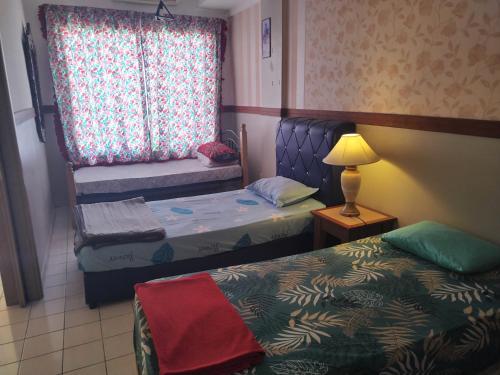 een kleine kamer met 2 bedden en een raam bij Shahmi Seaview Apartment (North) in Port Dickson