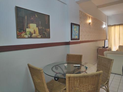 een eetkamer met een glazen tafel en stoelen bij Shahmi Seaview Apartment (North) in Port Dickson