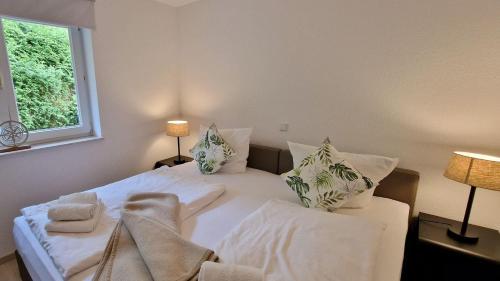 Un dormitorio con dos camas con almohadas y una ventana. en Haus-zum-Leuchtturm-Whg-02, en Sankt Peter-Ording