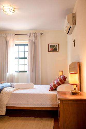 a bedroom with a large bed with a window at Casa de São Bernardo by LovelyStay in Lamego
