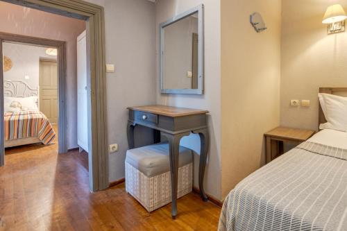 1 dormitorio con cama y escritorio con espejo en Aral Tatil Ciftligi, en Bozcaada