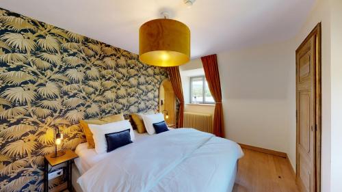 a bedroom with a bed with a blue and gold wallpaper at Les chambres de la Vaulx-Renard in La Gleize