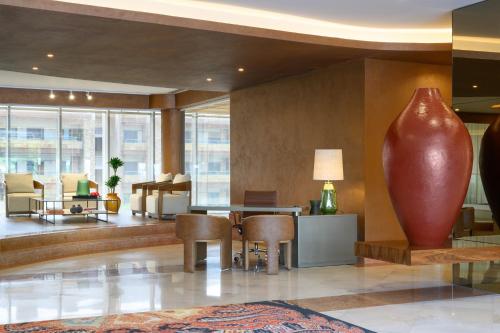 a lobby with a large vase on the wall at Hotel Coimbra Aeminium, Affiliated by Meliá in Coimbra