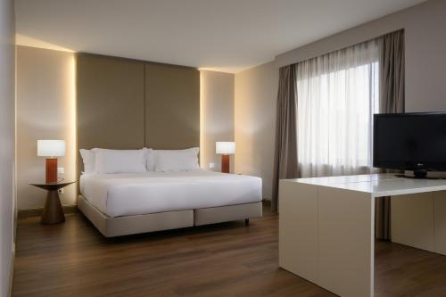 a bedroom with a bed and a flat screen tv at Hotel Coimbra Aeminium, Affiliated by Meliá in Coimbra