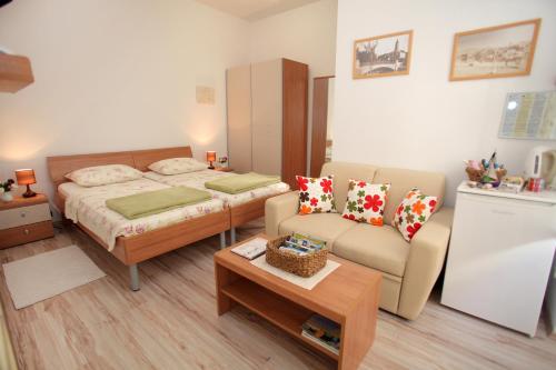 1 dormitorio con cama, sofá y mesa en Room Mira, en Trogir