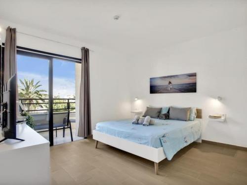 a white bedroom with a bed and a balcony at 212 Elegant, renovated, confortable Playa Paraiso in Playa Paraiso