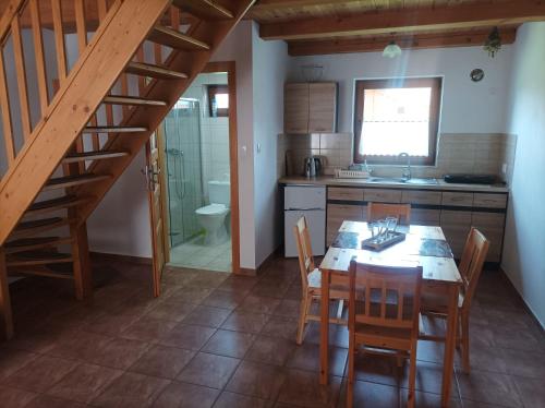 a kitchen with a table and chairs and a staircase at Domki Afrodyta in Jarosławiec