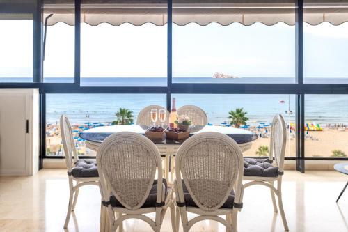 uma mesa de jantar com cadeiras e vista para a praia em Mucho Gusto Santa Margarita em Benidorm