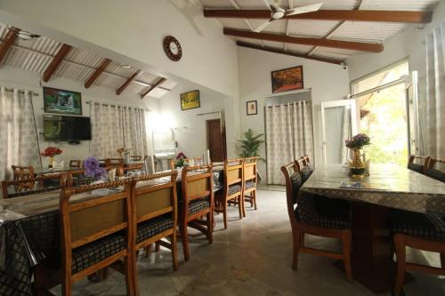 jadalnia z długim stołem i krzesłami w obiekcie Tiger Heaven Resort w mieście Bandhogarh Fort