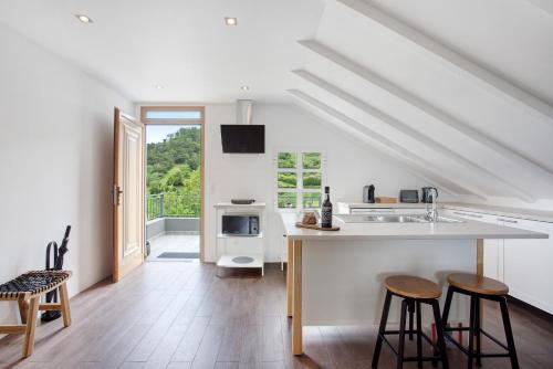 a kitchen with a sink and a counter with stools at Casa da Olides - T3 and Studio in Santana