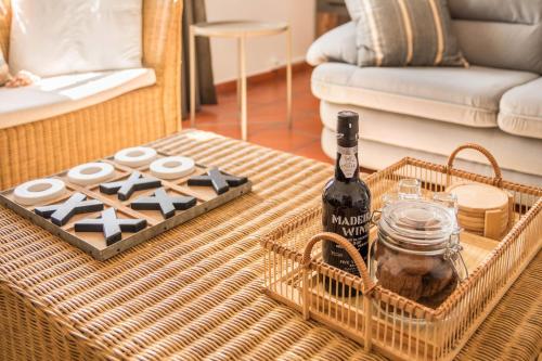 a bottle of wine on a table in a living room at Casa da Olides - T3 and Studio in Santana