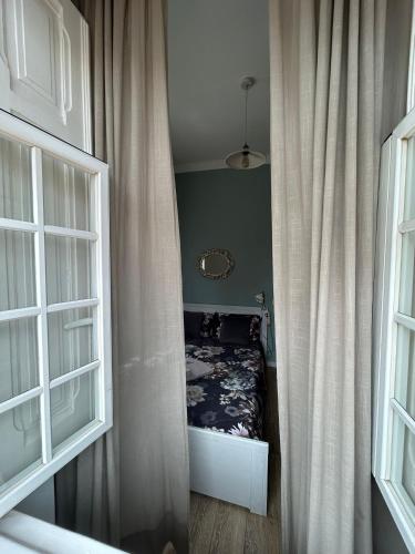 a hallway with a bed in a room with curtains at Eco Ljmonade Hostel in Cascais