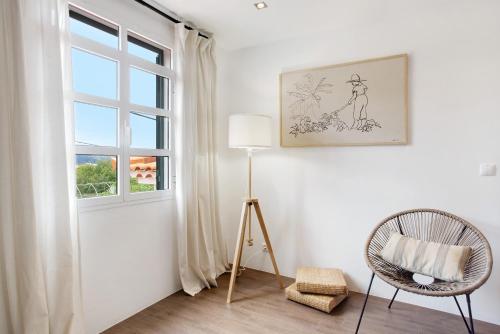 a room with a window and a chair and a lamp at Casa da Olides - Studio in Santana