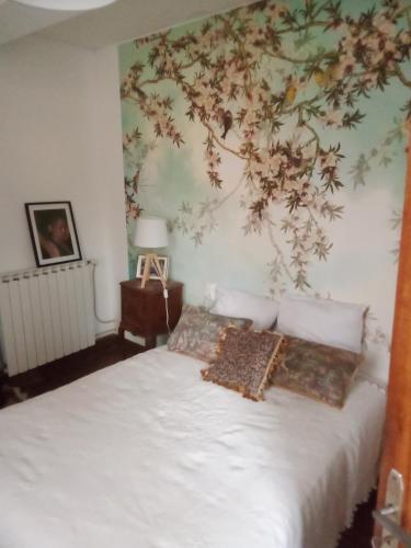 1 dormitorio con 1 cama blanca y un mural en la pared en Chemin des Écoliers 2 chambres doubles, en Soueich