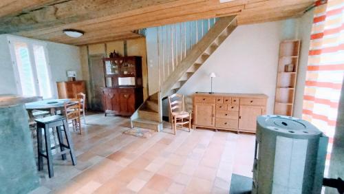 - un salon avec un escalier, une table et des chaises dans l'établissement APPARTEMENT 