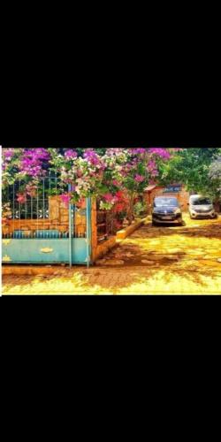 a gate with flowers on it with a car parked at HALİSE APART in Emecik