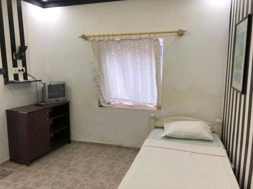 a small bedroom with a bed and a window at HALİSE APART in Emecik