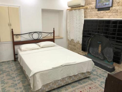 sypialnia z łóżkiem i kominkiem w obiekcie HALİSE APART w mieście Emecik