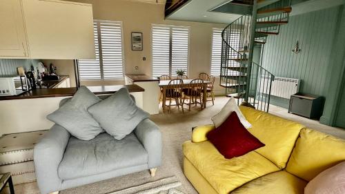 a living room with a couch and a kitchen at The Captain’s 4 Bed Penthouse in Fowey