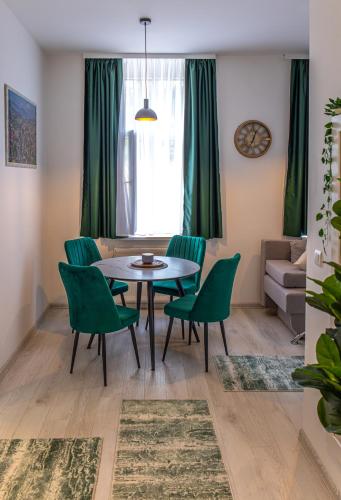 a living room with a table and green chairs at FIT Apartments in Sarajevo