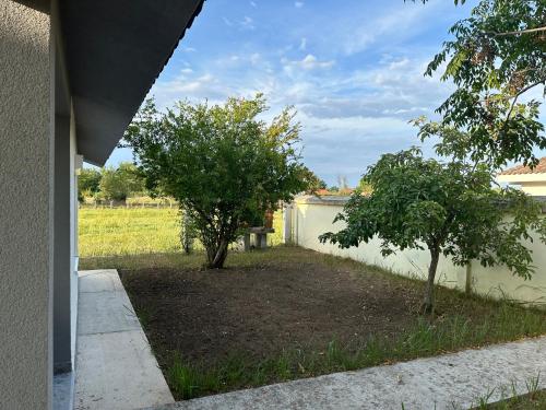 a yard with two trees next to a fence at Apartment Oki Ulcinj in Donji Štoj
