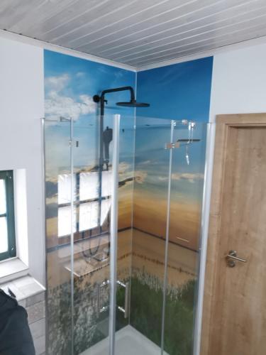 a bathroom with a shower with a painting on the wall at Ferienhaus Bultperle in Hüde