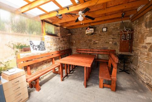 a patio with a wooden table and benches at Penzión Ružbaský in Stará Lesná