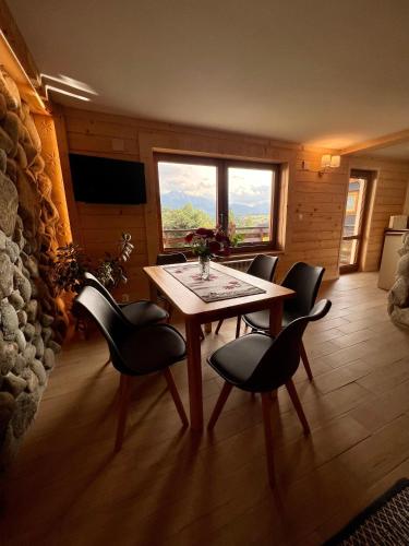 a dining room with a table and chairs and a window at Domek Olczyski in Zakopane