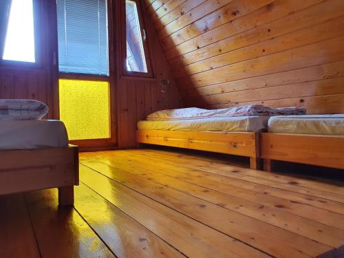a bedroom with two beds in a wooden cabin at Pod Mareszką in Krempna