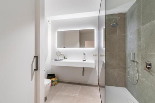 La salle de bains est pourvue d'un lavabo et d'une douche. dans l'établissement Modern appartement in hartje Oostende, à Ostende