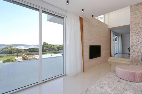 a living room with a large window and a tv at Villa Capan ZadarVillas in Sveti Filip i Jakov