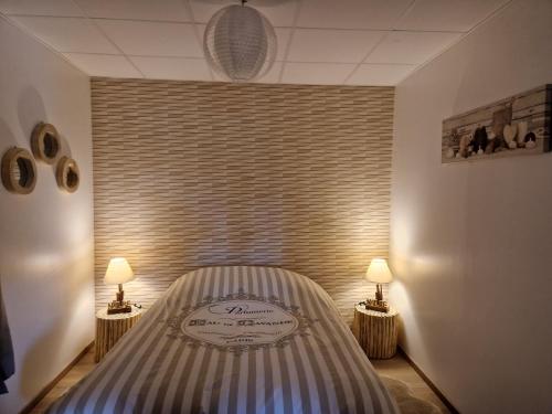 a bedroom with a bed with two lamps on either side at Gîte domaine de la galopade in Étréaupont