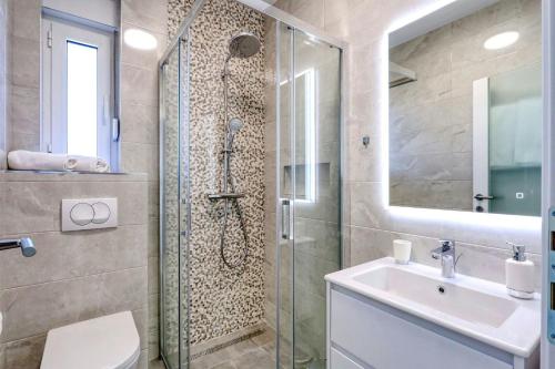 a bathroom with a shower and a toilet and a sink at Villa Capan ZadarVillas in Sveti Filip i Jakov