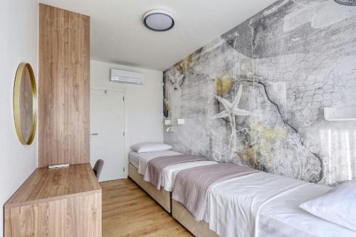 a bedroom with two beds and a stone wall at Villa Capan ZadarVillas in Sveti Filip i Jakov