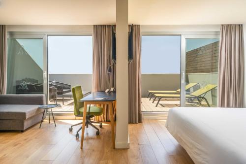 Cette chambre comprend un lit, un bureau et un balcon. dans l'établissement ARTIEM Madrid, à Madrid