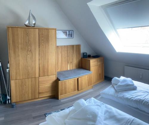 a room with two beds and a cabinet in a attic at Oasis 07 in Cuxhaven