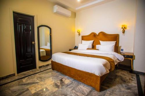 a bedroom with a large bed and a large mirror at The Rich Hotel & Apartments in Lahore
