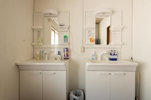 uma casa de banho com 2 lavatórios e um espelho em Bed&Cafe Onzo オンゾー em Onomichi