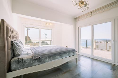 a bedroom with a bed with a view of the ocean at Chic Villa w Patio Pool 3 min to Beach in Bodrum in Gundogan