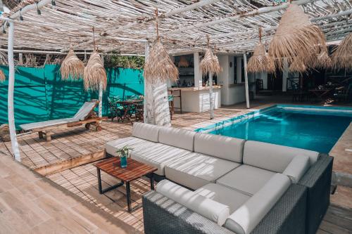 an outdoor patio with a couch and a swimming pool at Pili Pili Boho in Jambiani