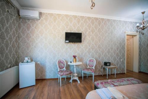 a room with a table and two chairs and a tv at Borjomi Classic Hotel in Borjomi