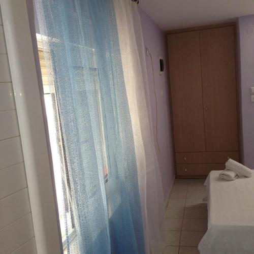 a bathroom with a shower curtain and a window at Zefyros Hotel in Rhodes Town