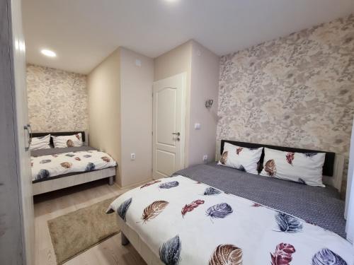 um quarto com 2 camas e uma parede em Apartman Savić em Bajina Bašta