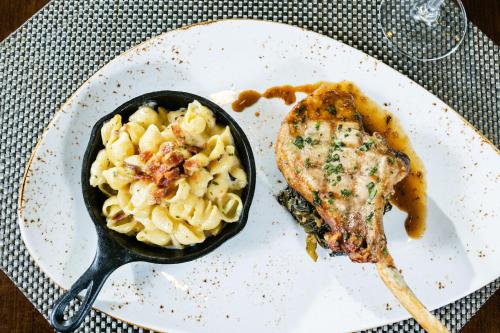 a plate with a bowl of pasta and a piece of fish at The Westin Hilton Head Island Resort & Spa in Hilton Head Island